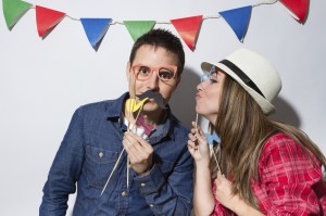 Young couple in a Photo Booth party with garland decoration background